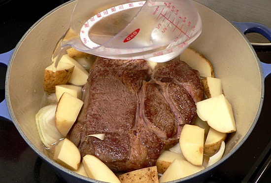 Cho khoai tây hành tây và nước vào nồi thịt