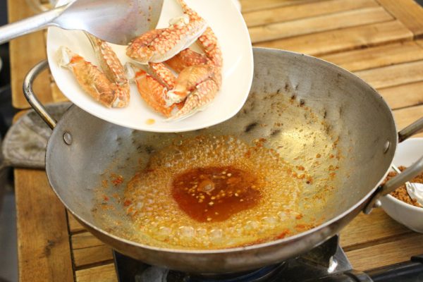 Đun chảo nóng rồi cho càng ghẹ và hỗn hợp muối ớt vào rang đều tay