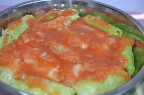 Cho các cuộn cải vào khay rưới nước sốt cà chua lên mặt cải