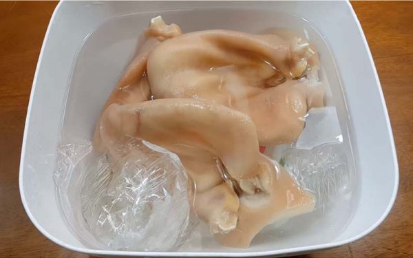 Tai heo chín vớt ra cho ngay vào bát nước đá lạnh