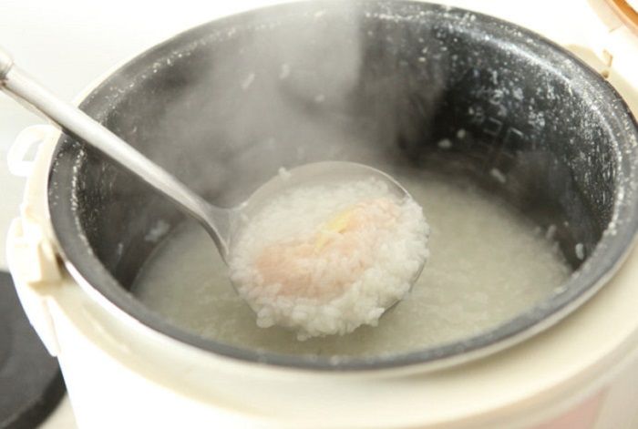 Cho thịt gà vào nồi cháo khuấy đều tay