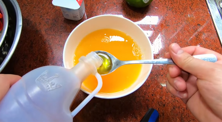 Cho thêm mật ong vào chén nước cam