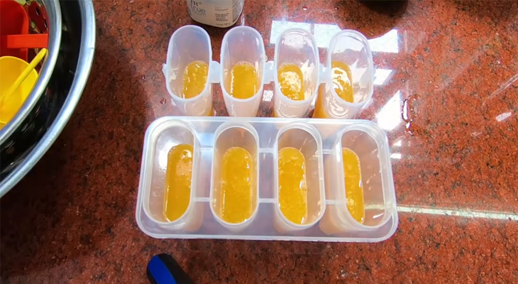 Cho nước cam mật ong vào khuôn làm lớp kem cam