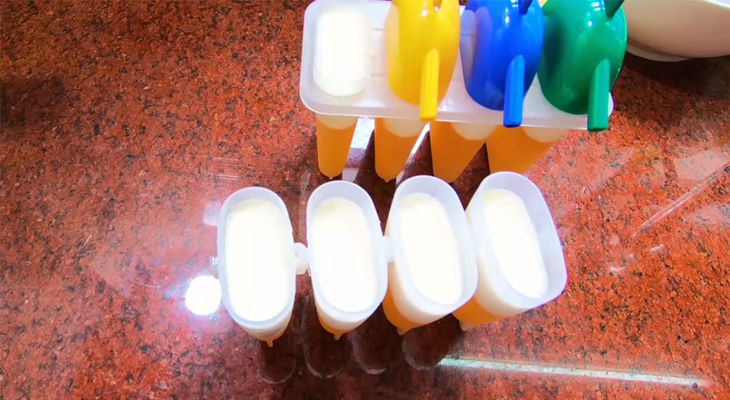 Đổ hỗn hợp sữa vào khuôn kem cam rồi cho vào tủ lạnh cho đông lại